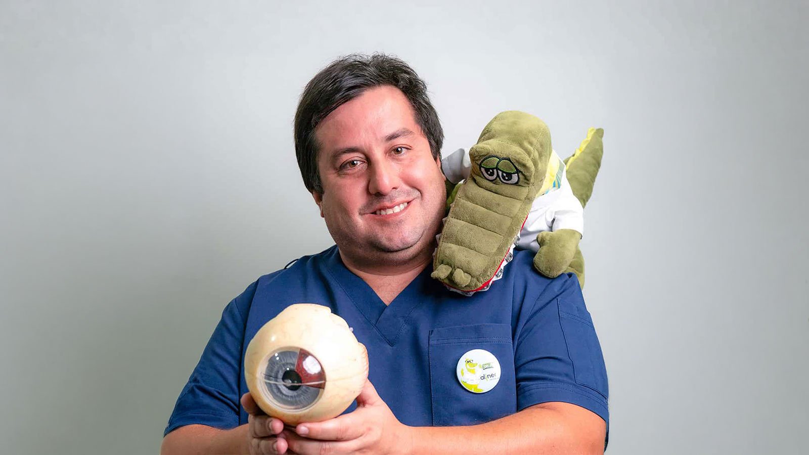 El Dr. Claudio Cuadros con la mascota D'Ali y un modelo anatómico de ojo