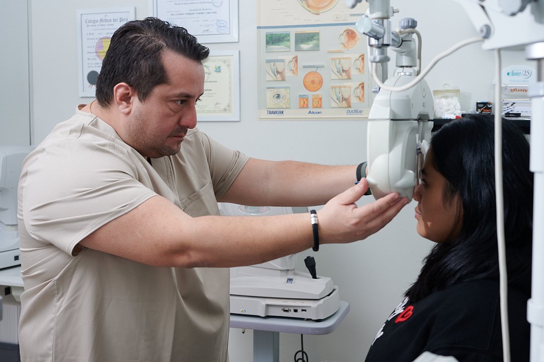 El Dr. Claudio Cuadros explorando a una paciente en la lámpara de hendidura